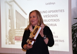 R. Tamoliūnienė laiko rankų darbo bibliotekos istorijos leidinį